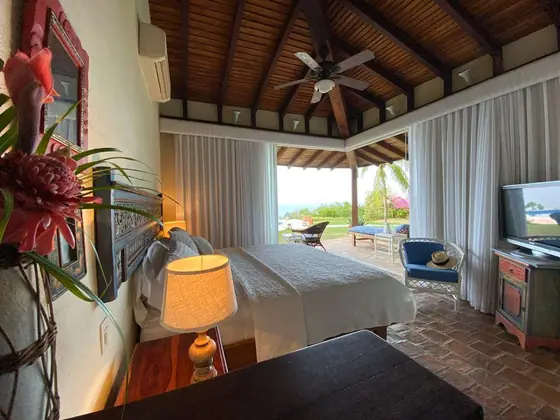 Habitación 01: suite abierta con cama king y terraza frente al mar
