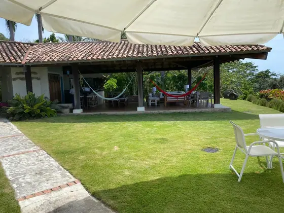 Terraza techada de la casa con hamacas y comedor